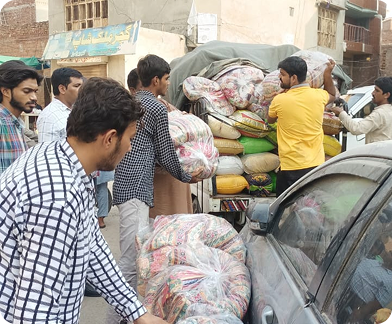 A group of men packing bags into cars