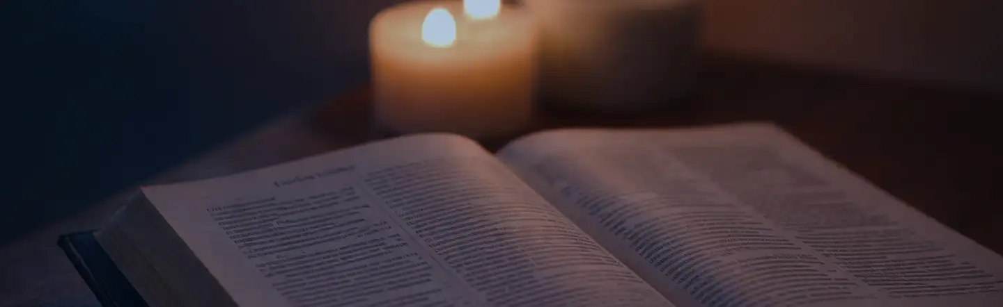 Open Bible with candlelight in the background